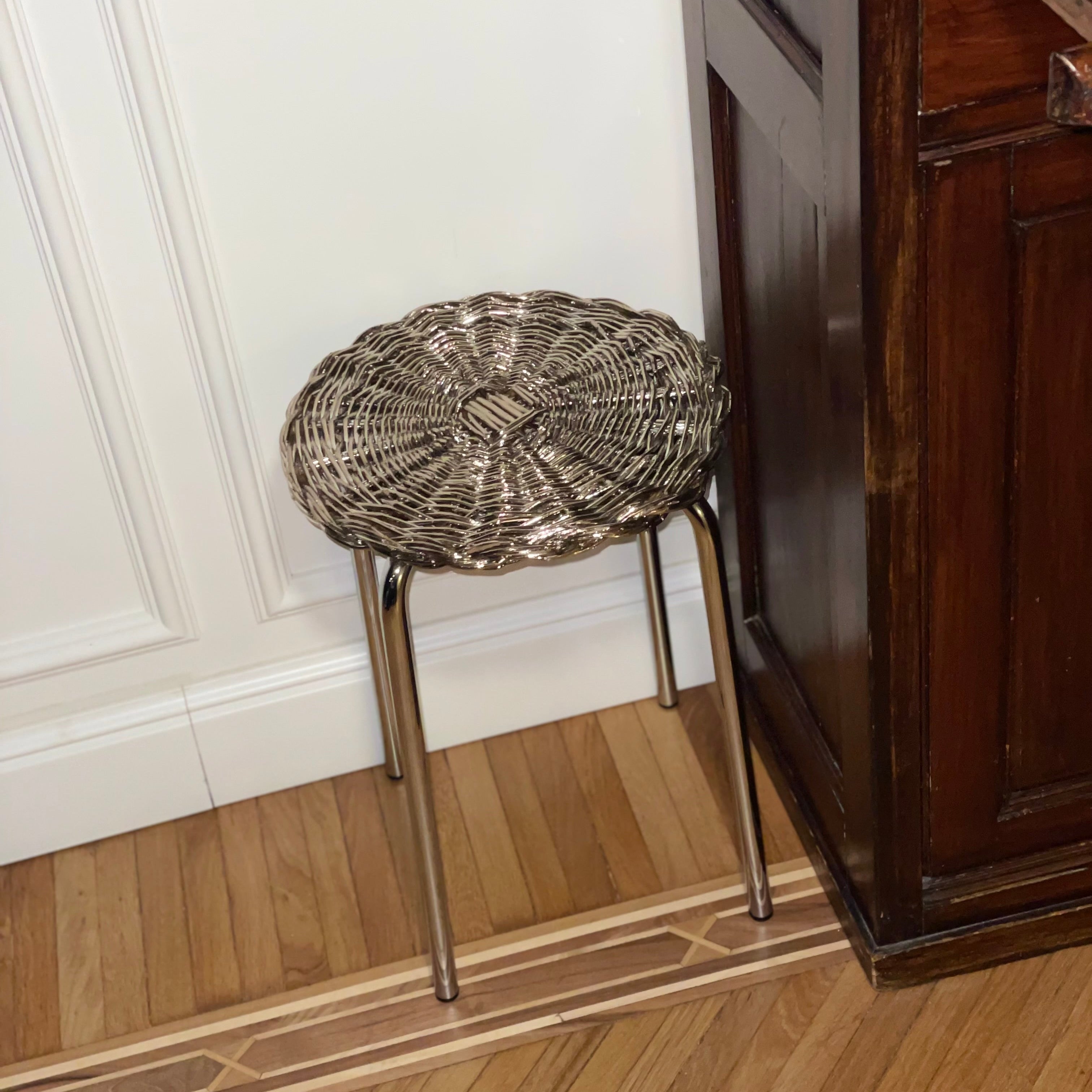 Stool cromato con seduta intrecciata color argento, complemento di design per interni raffinati e moderni